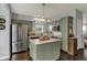Stylish kitchen featuring modern appliances, a center island, and muted-green cabinets with dark wood floors at 3466 Firethorn Dr, Whitestown, IN 46075