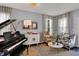 Elegant living room with a grand piano, stylish seating, and neutral decor, creating a welcoming ambiance at 3466 Firethorn Dr, Whitestown, IN 46075