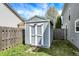 A backyard shed with white doors provides additional storage, with grass all around and a fence nearby at 3466 Firethorn Dr, Whitestown, IN 46075