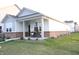 Inviting single-story home featuring a brick foundation, a welcoming front porch, and well-manicured lawn at 360 Lincoln W Cir, Fortville, IN 46040