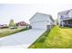 View of the home's exterior, showcasing the driveway and garage with a well manicured lawn at 360 Lincoln W Cir, Fortville, IN 46040