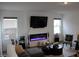 This is a comfortable living room with a modern electric fireplace and large TV at 360 Lincoln W Cir, Fortville, IN 46040