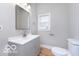 Clean bathroom with gray vanity, white countertops, modern fixtures, and a window for natural light at 3758 Broadway St, Indianapolis, IN 46205