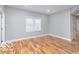 Bright bedroom with hardwood floors, white trim, neutral gray walls, and a window for natural light at 3758 Broadway St, Indianapolis, IN 46205