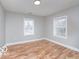 Spacious bedroom with hardwood floors, neutral gray walls, and two windows at 3758 Broadway St, Indianapolis, IN 46205