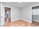 Bright bedroom with hardwood floors, neutral gray walls, and two entryways at 3758 Broadway St, Indianapolis, IN 46205