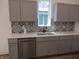 Modern kitchen featuring a stainless steel dishwasher, farmhouse sink, and patterned backsplash at 4234 Kingsley Dr, Indianapolis, IN 46205