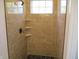 Shower featuring glass door, tiled walls, and corner shelves at 4234 Kingsley Dr, Indianapolis, IN 46205