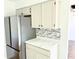 Modern kitchen with stainless steel refrigerator, white cabinets, and updated countertops at 436 Tavistock Dr, Mooresville, IN 46158