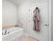 Relaxing bathroom showcasing a soaking tub, neutral walls, and a robe, ideal for unwinding after a long day at 4557 Marigold Ct, Greenwood, IN 46143