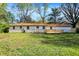 Large backyard featuring a wooden deck, lush green lawn, and the rear of a charming home at 4775 E 56Th St, Indianapolis, IN 46220