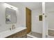 Bathroom features a wooden vanity, gold fixtures, and a beautifully tiled shower with built-in shelf at 4775 E 56Th St, Indianapolis, IN 46220