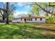 Inviting single-story home with a large front lawn and mature trees on a sunny day at 4775 E 56Th St, Indianapolis, IN 46220
