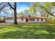 Charming single-story home featuring a brick facade, well-maintained lawn, and mature trees at 4775 E 56Th St, Indianapolis, IN 46220