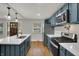 Modern kitchen with stainless steel appliances, shaker cabinets, a quartz countertop island, and hardwood floors at 4775 E 56Th St, Indianapolis, IN 46220