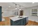 Open-concept kitchen featuring a quartz countertop island, stainless steel appliances, and hardwood floors at 4775 E 56Th St, Indianapolis, IN 46220
