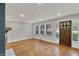 Bright living room featuring hardwood floors, a cozy fireplace, and a wooden front door at 4775 E 56Th St, Indianapolis, IN 46220