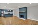 Open-concept living room with hardwood floors, a fireplace, and a view into the adjacent kitchen at 4775 E 56Th St, Indianapolis, IN 46220