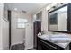 Bathroom featuring a modern vanity, decorative mirror, and walk-in shower with neutral color palette at 4917 Melbourne Rd, Indianapolis, IN 46228