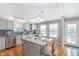 Bright kitchen features an island with seating, stainless steel appliances, and gray cabinets at 4917 Melbourne Rd, Indianapolis, IN 46228