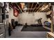Unfinished basement area set up with exercise equipment, including a treadmill, weights, and a bench at 5034 N Illinois St, Indianapolis, IN 46208