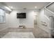 Finished basement featuring plush carpet, a mounted TV, and access to a staircase with white railings at 5034 N Illinois St, Indianapolis, IN 46208