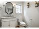 Charming powder room features a marble countertop, framed mirror and decorative sconces at 5034 N Illinois St, Indianapolis, IN 46208