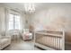 Cozy Bedroom with a white crib, comfortable armchairs, chandelier and decorative wall art at 5034 N Illinois St, Indianapolis, IN 46208