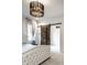 Bright bedroom with a tufted headboard, modern chandelier, and rustic barn door at 5034 N Illinois St, Indianapolis, IN 46208