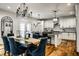 Bright dining room features hardwood floors, blue velvet chairs and a modern chandelier next to the kitchen at 5034 N Illinois St, Indianapolis, IN 46208
