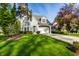 Charming two-story home featuring a manicured lawn, attached garage, and lovely curb appeal on a sunny day at 5034 N Illinois St, Indianapolis, IN 46208