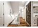 Bright hallway featuring hardwood floors, a modern staircase, and a stylish barn door enhancing the home's character at 5034 N Illinois St, Indianapolis, IN 46208