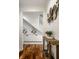 Hallway featuring hardwood floors, a wood table and decor with a staircase in the background at 5034 N Illinois St, Indianapolis, IN 46208