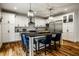 Spacious kitchen boasts white cabinets, a black countertop island with pendant lights and hardwood floors at 5034 N Illinois St, Indianapolis, IN 46208