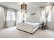 Bright main bedroom with tufted headboard, light carpet, and drapery-framed windows at 5034 N Illinois St, Indianapolis, IN 46208