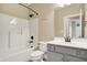 Cozy bathroom featuring a shower-tub combo and a gray vanity with modern fixtures at 5212 Knollton Rd, Indianapolis, IN 46228