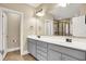 Bathroom with dual sinks, gray cabinets, granite countertops, and a walk-in shower at 5212 Knollton Rd, Indianapolis, IN 46228