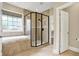 Modern bathroom featuring a luxurious shower, a soaking tub and neutral tile at 5212 Knollton Rd, Indianapolis, IN 46228