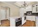 Well-equipped kitchen island boasts stainless steel oven, microwave, white cabinets, and marble countertop at 5212 Knollton Rd, Indianapolis, IN 46228