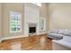 Cozy living room featuring a fireplace with stone surround, hardwood floors, and ample natural light at 5212 Knollton Rd, Indianapolis, IN 46228