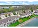 Scenic aerial view of townhomes by the water featuring green lawns and mature trees at 5453 Nighthawk Way, Indianapolis, IN 46254