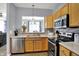 Functional kitchen with stainless steel appliances, light countertops, and view to dining area at 5453 Nighthawk Way, Indianapolis, IN 46254