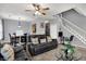 Open-concept living room showcasing a comfortable sofa, dining area, staircase, and neutral wall color at 5453 Nighthawk Way, Indianapolis, IN 46254