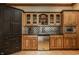 Basement bar featuring wood cabinets, stainless steel fridge, and a tile backsplash at 553 Bolderwood Ln, Carmel, IN 46032