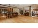 Open basement area featuring bar seating, a stone fireplace, and hardwood floors at 553 Bolderwood Ln, Carmel, IN 46032