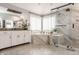 Luxurious bathroom featuring marble-tiled shower with glass doors, soaking tub, and spacious white cabinets at 553 Bolderwood Ln, Carmel, IN 46032