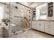 Elegant bathroom featuring marble-tiled shower with glass doors, white cabinets, and decorative plant at 553 Bolderwood Ln, Carmel, IN 46032