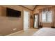 Bedroom featuring stylish curtains, textured walls, a window view, and a large mirror and door to bathroom at 553 Bolderwood Ln, Carmel, IN 46032