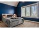 This bedroom features a large window, blue accent wall, and a cozy, well-appointed gray bed at 553 Bolderwood Ln, Carmel, IN 46032