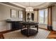 Formal dining room featuring hardwood floors, wainscoting, neutral paint, and statement furniture at 553 Bolderwood Ln, Carmel, IN 46032